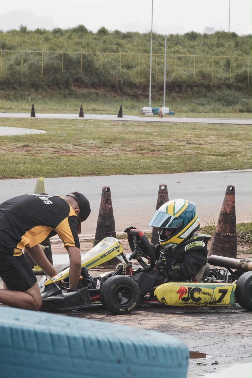 Carros disputando curva fechada sob o sol no autódromo